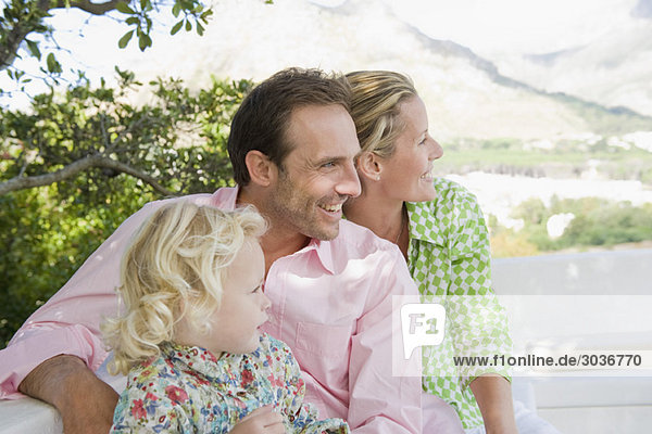 Familie lächelt auf der Terrasse