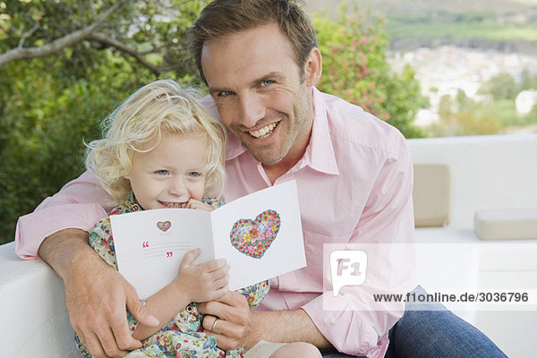 Porträt eines Mannes mit seiner Tochter im Besitz einer Grußkarte