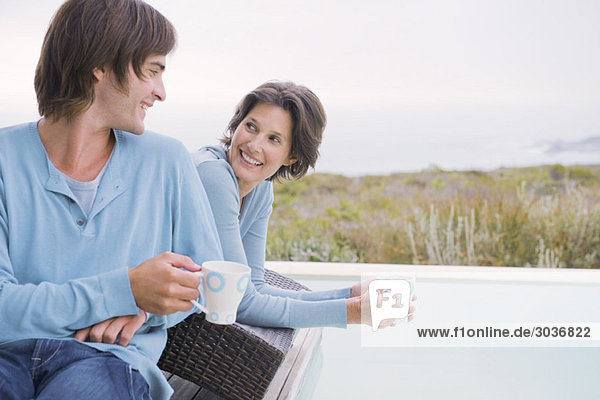 Frau und Sohn beim Tee trinken am Pool