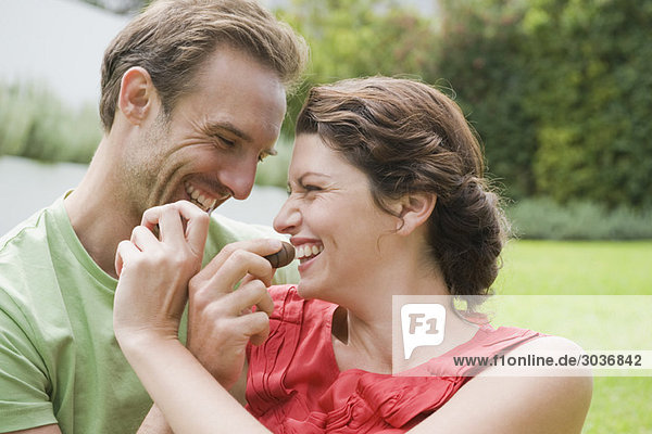 Paare füttern sich gegenseitig mit Schokolade und lächeln