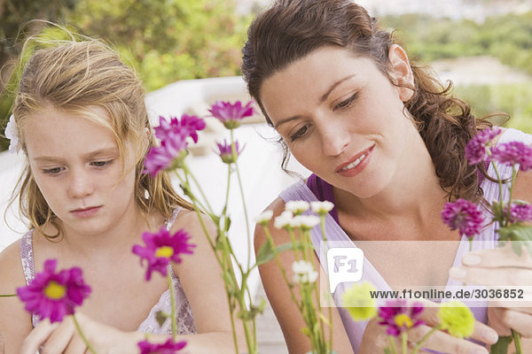 Frau mit ihrer Tochter beim Blumenarrangement