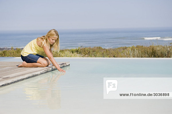Girl playing on a platform at an infinity pool