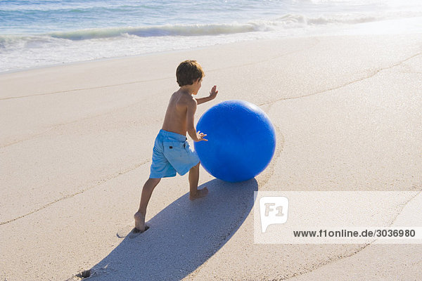 Junge spielt mit einem Strandball
