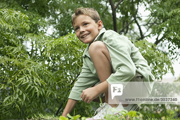Junge spielt im Garten und lächelt