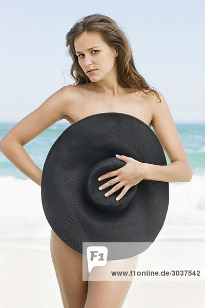 Frau  die ihren Körper mit einem Hut bedeckt.