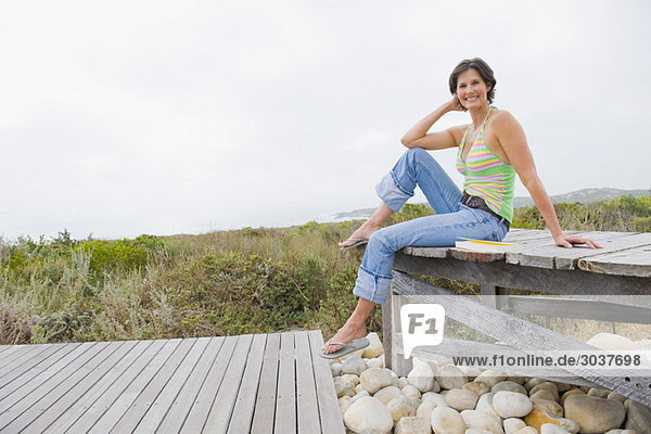 Woman sitting on a boardwalk