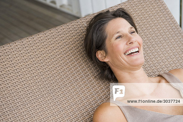 Woman lying on a porch swing and smiling