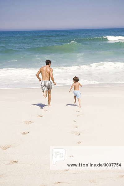 Man running with his son on the beach