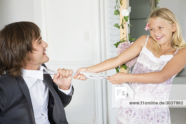Girl pulling a groom by tie
