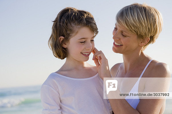Frau mit ihrer Tochter im Urlaub am Strand