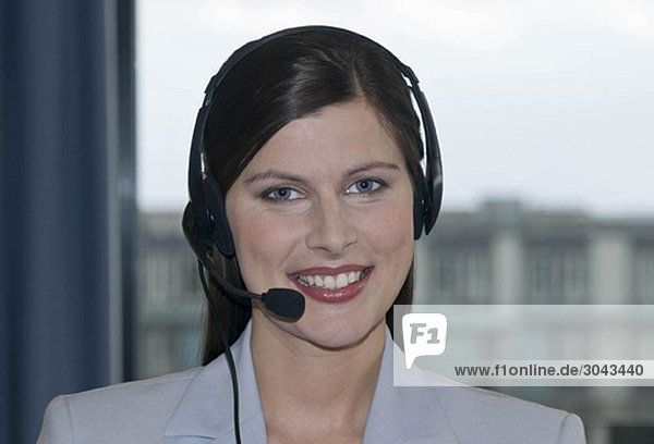 Geschäftsfrau mit Kopfhörer  lächelnd