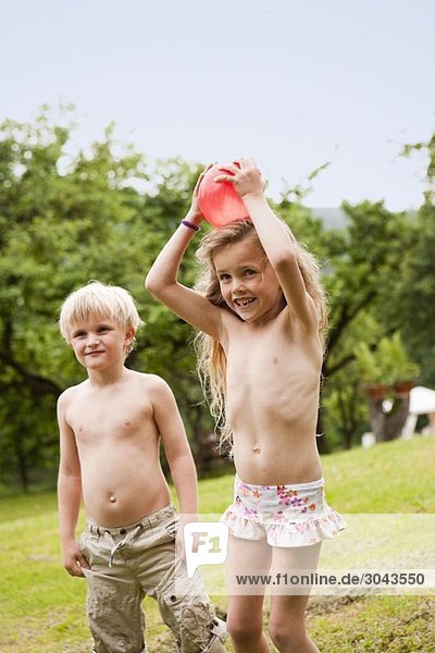 Junge und Mädchen spielen im Garten