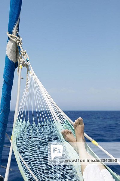 Woman's feet in hammock on sailing boat