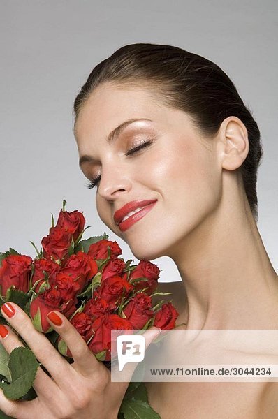 Weibliches Schönheitsmodell duftende Rosen