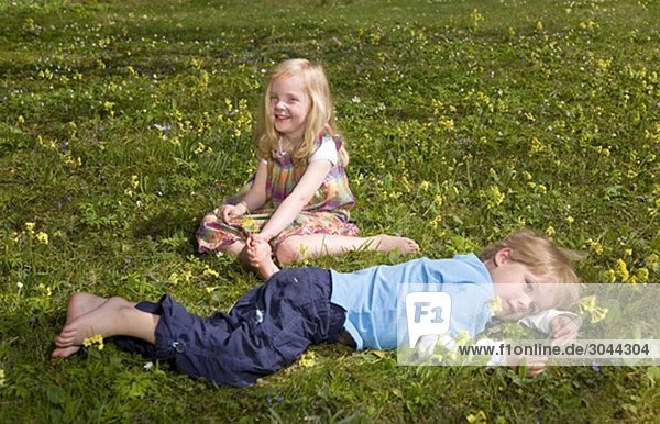 girl and boy lying in grass