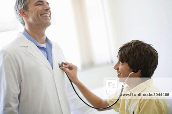 Junge hört dem männlichen Arztherz zu