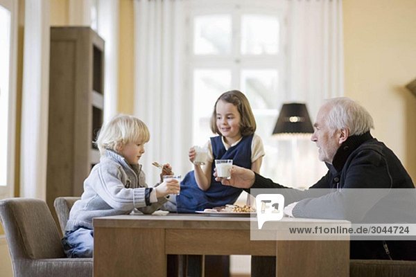 grandfather and grandchildren eating