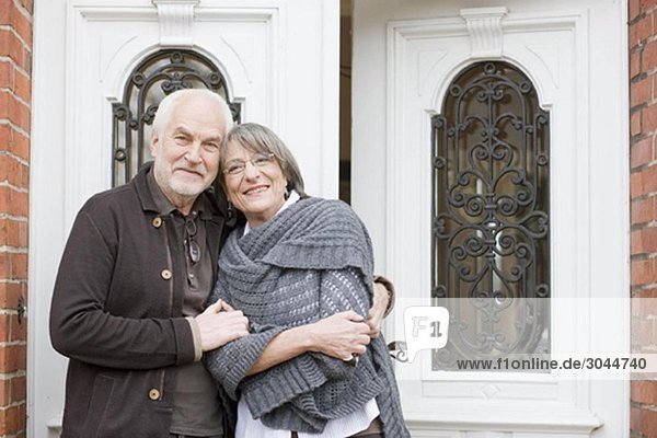 altes Ehepaar steht vor der Haustür