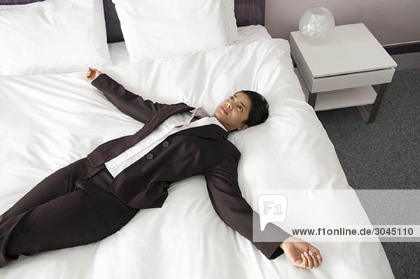 Frau auf einem Bett mit ausgestreckten Armen