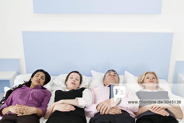 Vier Geschäftsleute im Bett