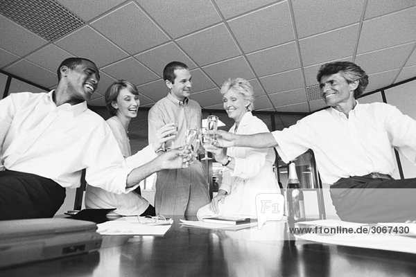 Geschäftsfreunde klirren an den Gläsern  feiern mit Champagner im Büro