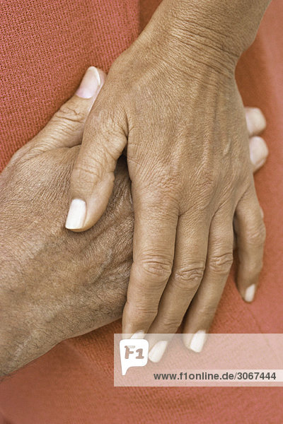Woman's hand resting on top of man's hand  close-up