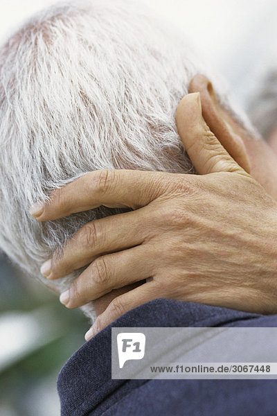 Woman's hand on back of man's neck  close-up
