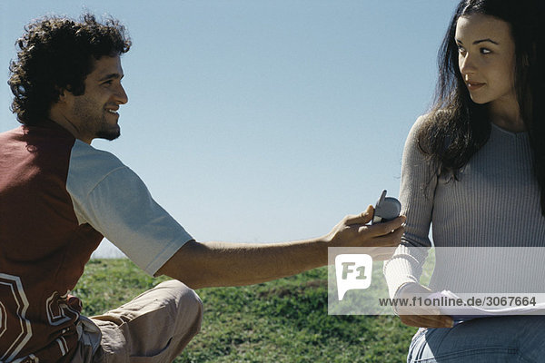 Young man showing cell phone to woman