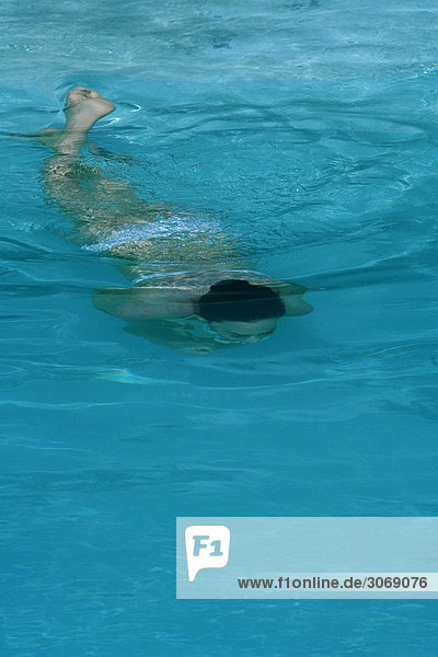 Woman swimming underwater  full length
