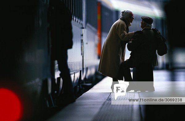 Zwei ältere Menschen auf dem Bahnsteig