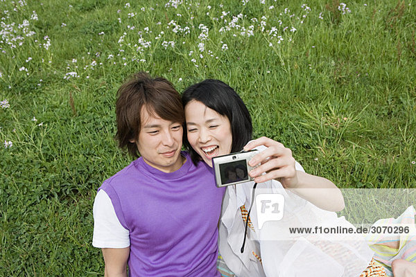 Junges Paar auf dem Feld mit Kamera