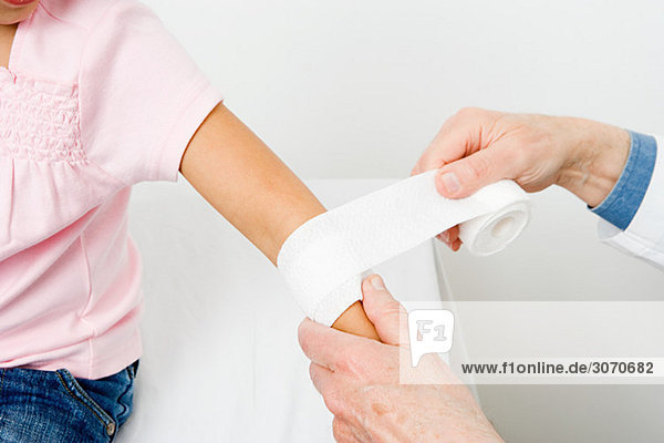 Girl having bandage put on arm