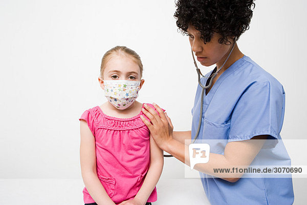 Nurse and girl in protective mask