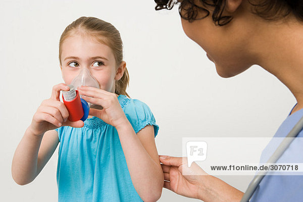 Girl taking asthma inhaler