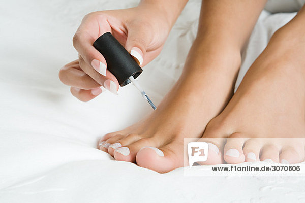 Woman painting toenails