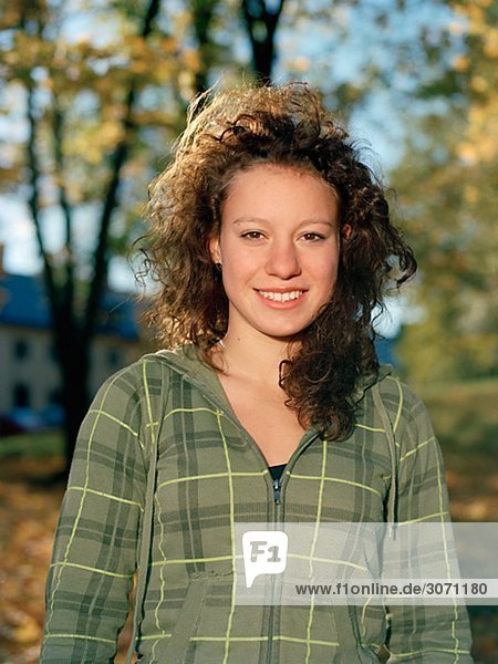Portrait einer lächelnd Teenagerin in der herbstliche Sonne Schweden.