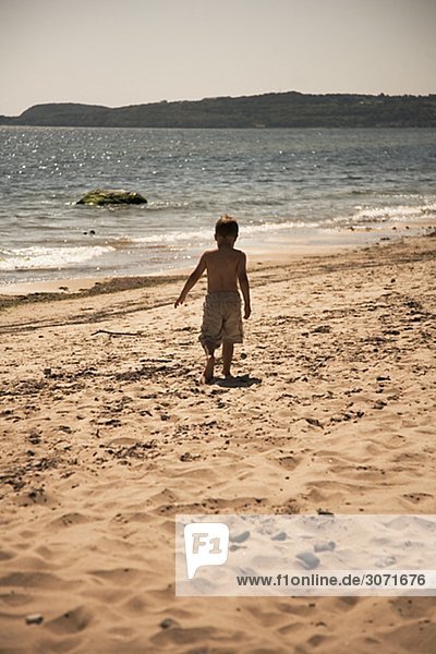 Ein Junge auf einem Strand Schweden zu Fuß.