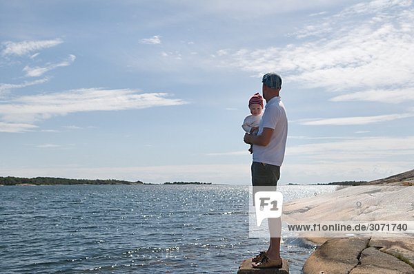 Vater mit Kindern am Meer Schweden.