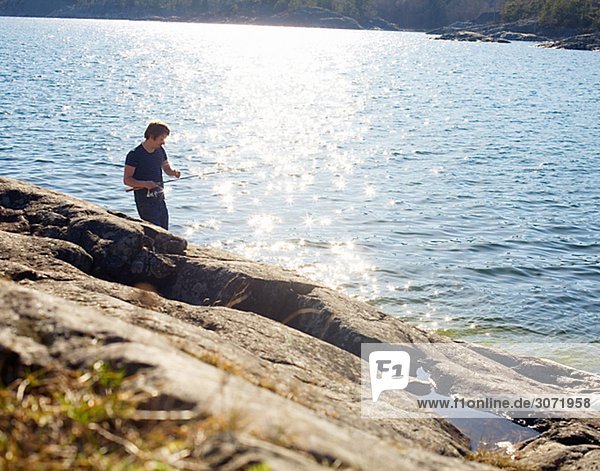 A man fishing by the sea Sweden.