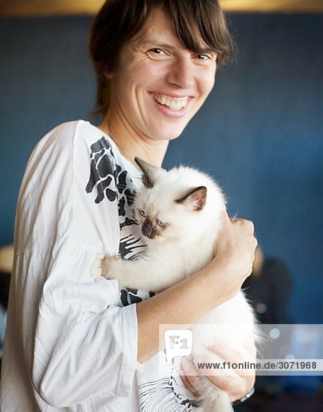 A smiling Frau hält ein weißen Kätzchen Schweden.