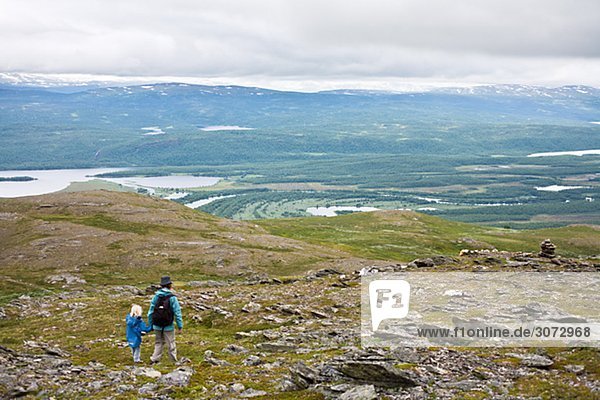 Mutter und Kind zu Fuß auf der bloßen Bergregion oberhalb der Baumgrenze Schweden