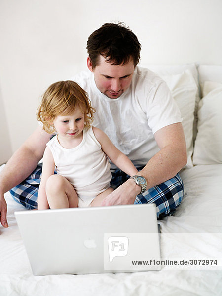 Father and daughter in front of a laptop Sweden