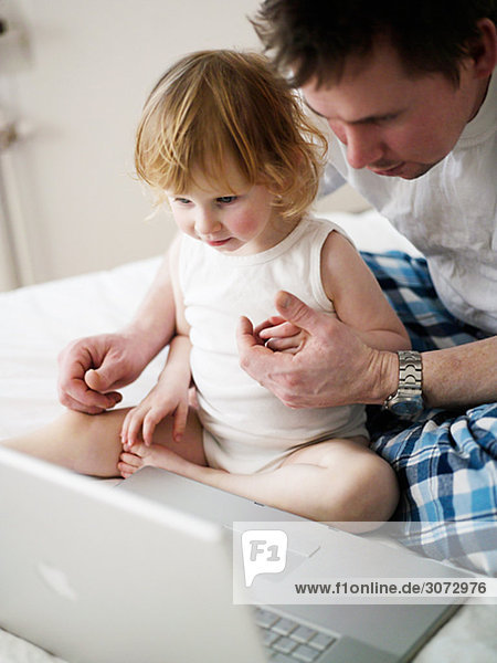 Father and daughter in front of a laptop Sweden