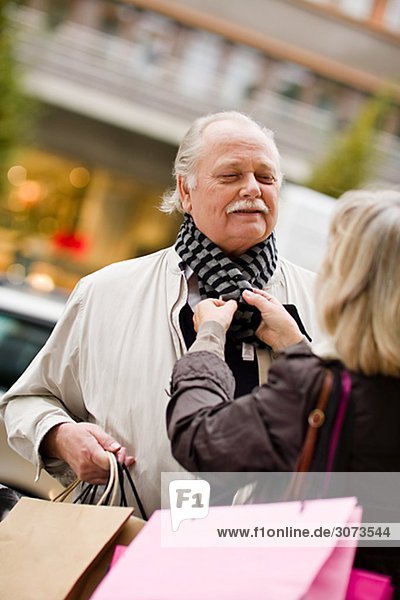 A senior couple carrying shopping bags Sweden.