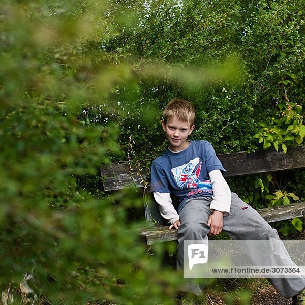 A boy sitting on a bench Sweden.