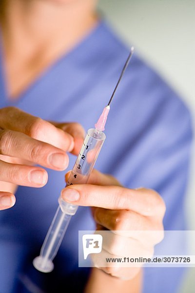 Nurse preparing injection close-up.