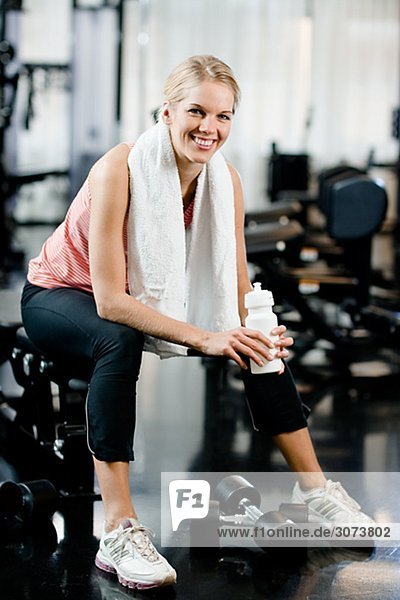 A woman with a water bottle at a gym Sweden.
