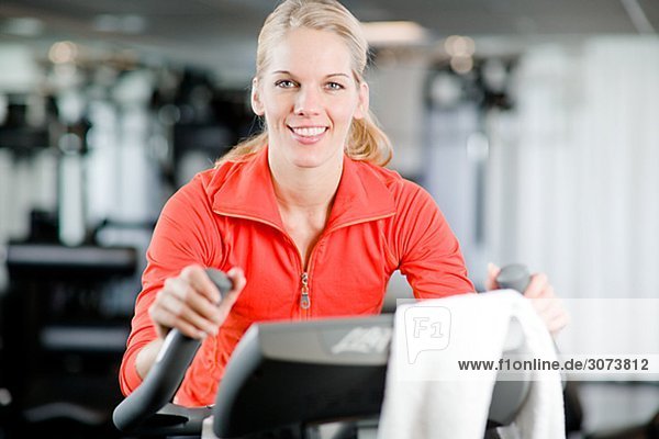 A woman doing indoor cycling at a gym Sweden.