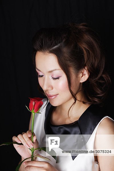 Woman with Closed Eyes Holding Red Rose