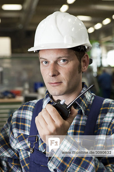 Portrait of a factory worker holding a walkie-talkie